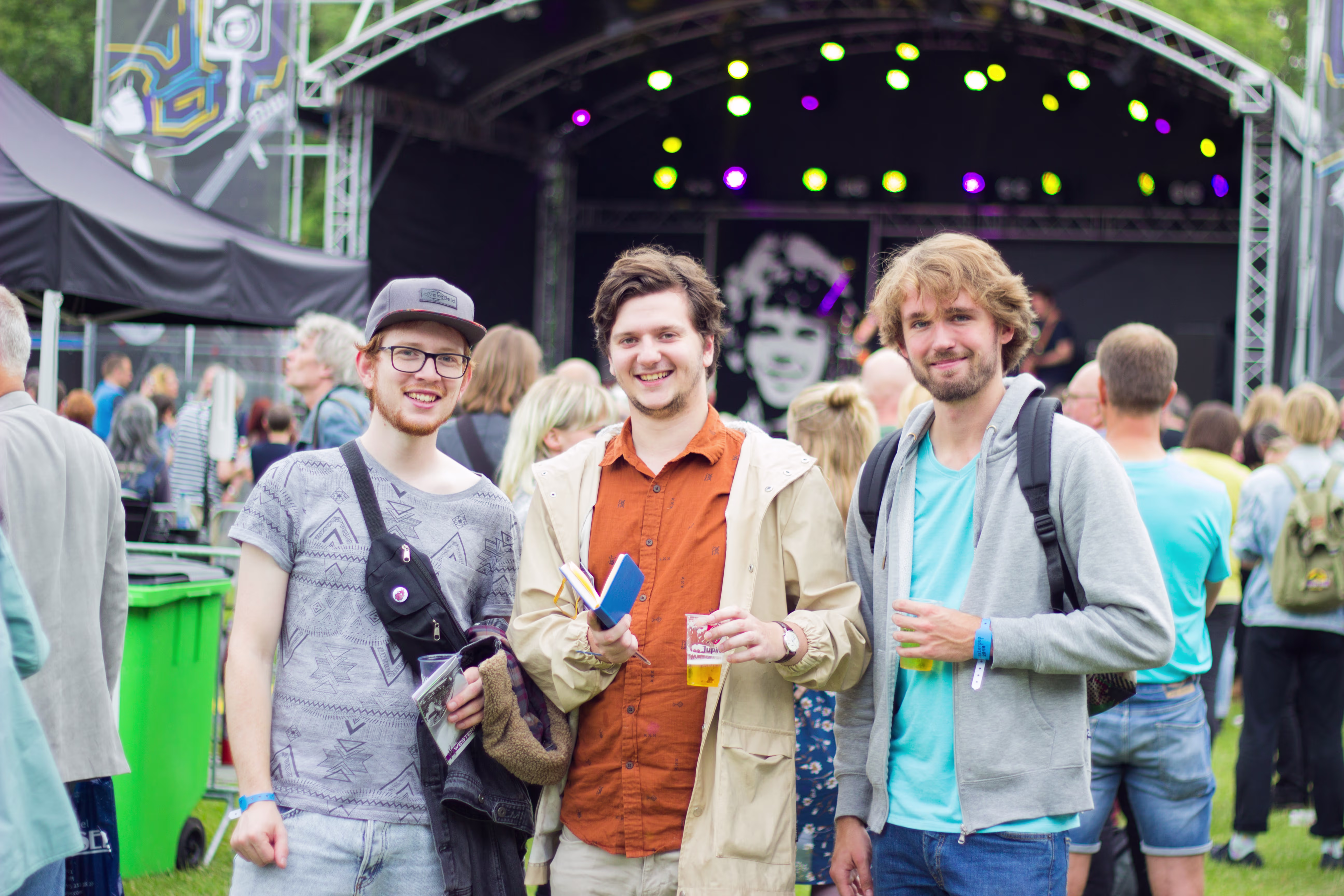 Mathijs Verstegen (midden) met twee collega’s van 3voor12 Delft tijdens Westerpop 2019, voor het podium met publiek op de achtergrond.